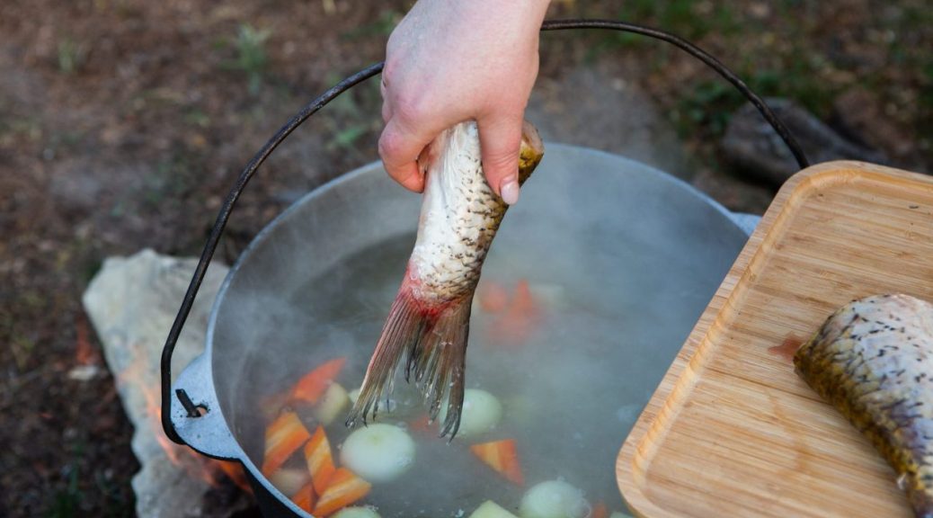 Personne aérant une cuisine ouverte après la cuisson d’un poisson.
