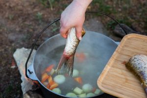 Personne aérant une cuisine ouverte après la cuisson d’un poisson.