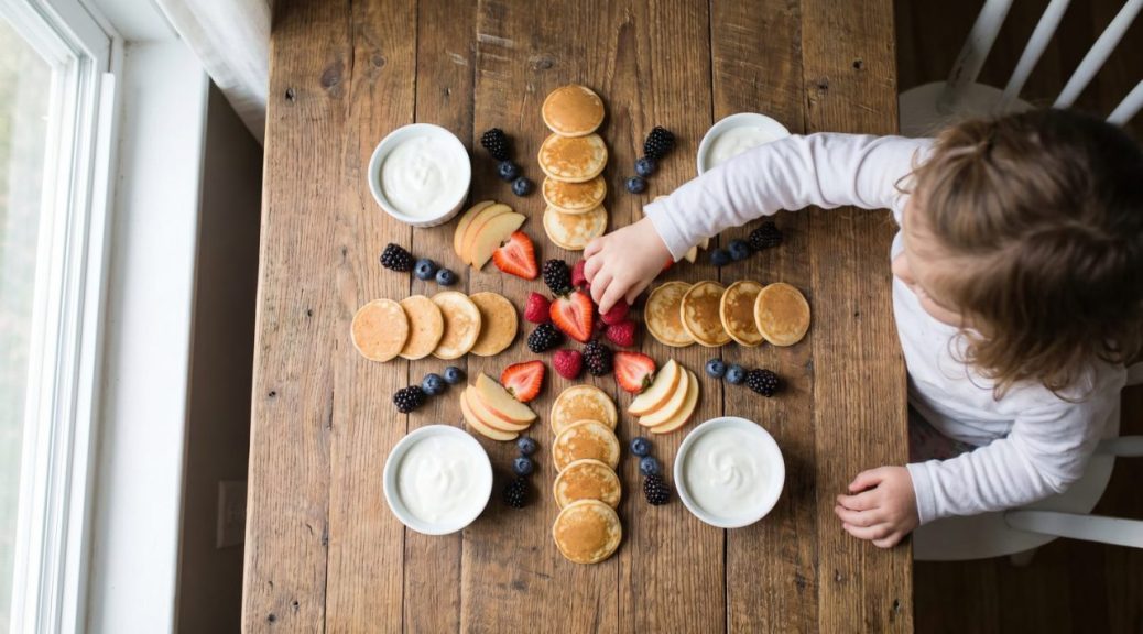 Coin petit-déjeuner organisé avec bols, céréales et verres placés à hauteur des enfants.