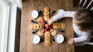 Coin petit-déjeuner organisé avec bols, céréales et verres placés à hauteur des enfants.