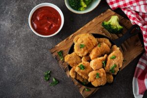 Nuggets de poulet maison croustillants servis dans une assiette, avec une texture dorée et tendre.